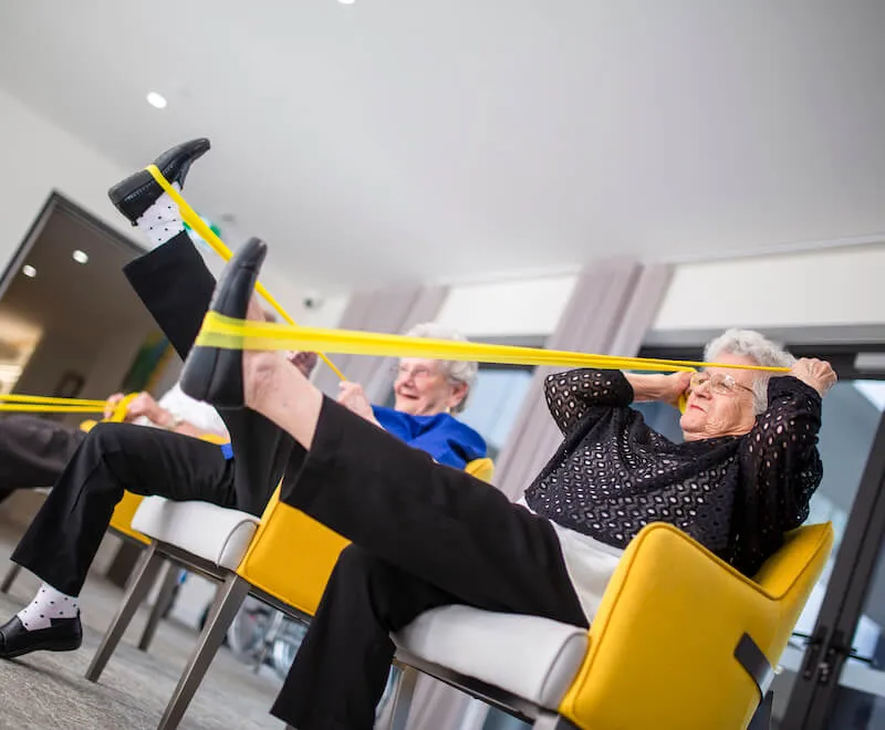 Residents participating in guided strength exercises as part of a wellness-focused aged care lifestyle.