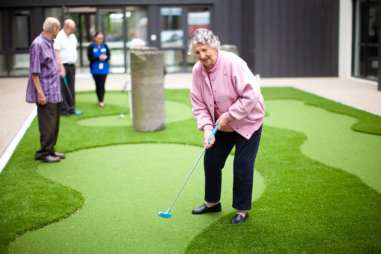 Resident participating in outdoor mini golf activity to support mobility and physical wellbeing.