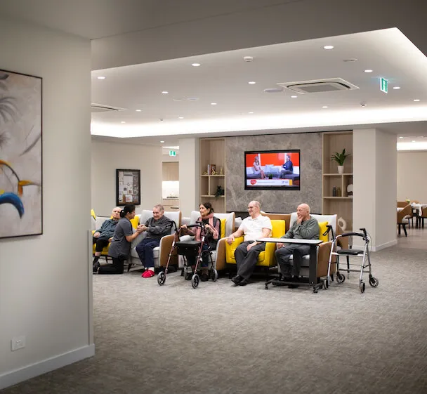 Residents relaxing together in a shared lounge space during a group lifestyle activity.