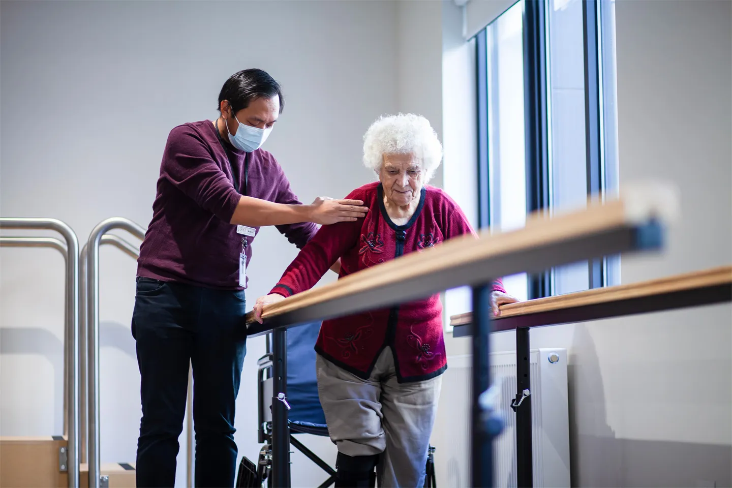 Care team member assisting a resident with walking and balance during daily movement support.