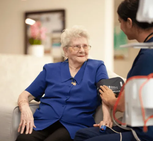 Care staff member supporting a resident during a routine health check.