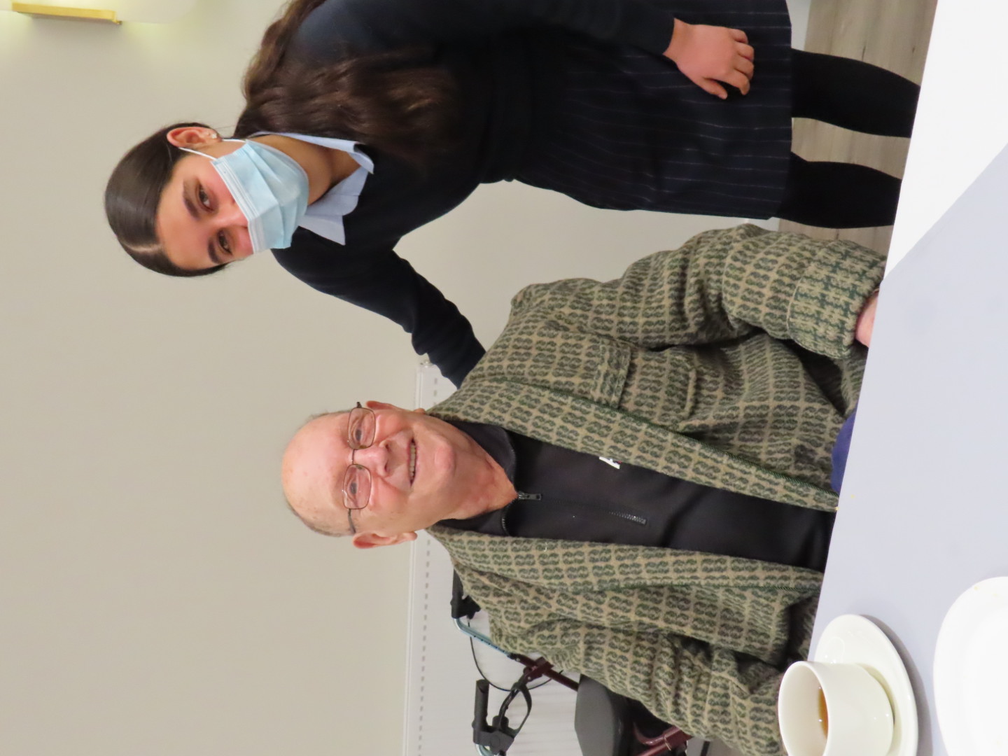 Care team member providing friendly support to an aged care resident during a social visit.