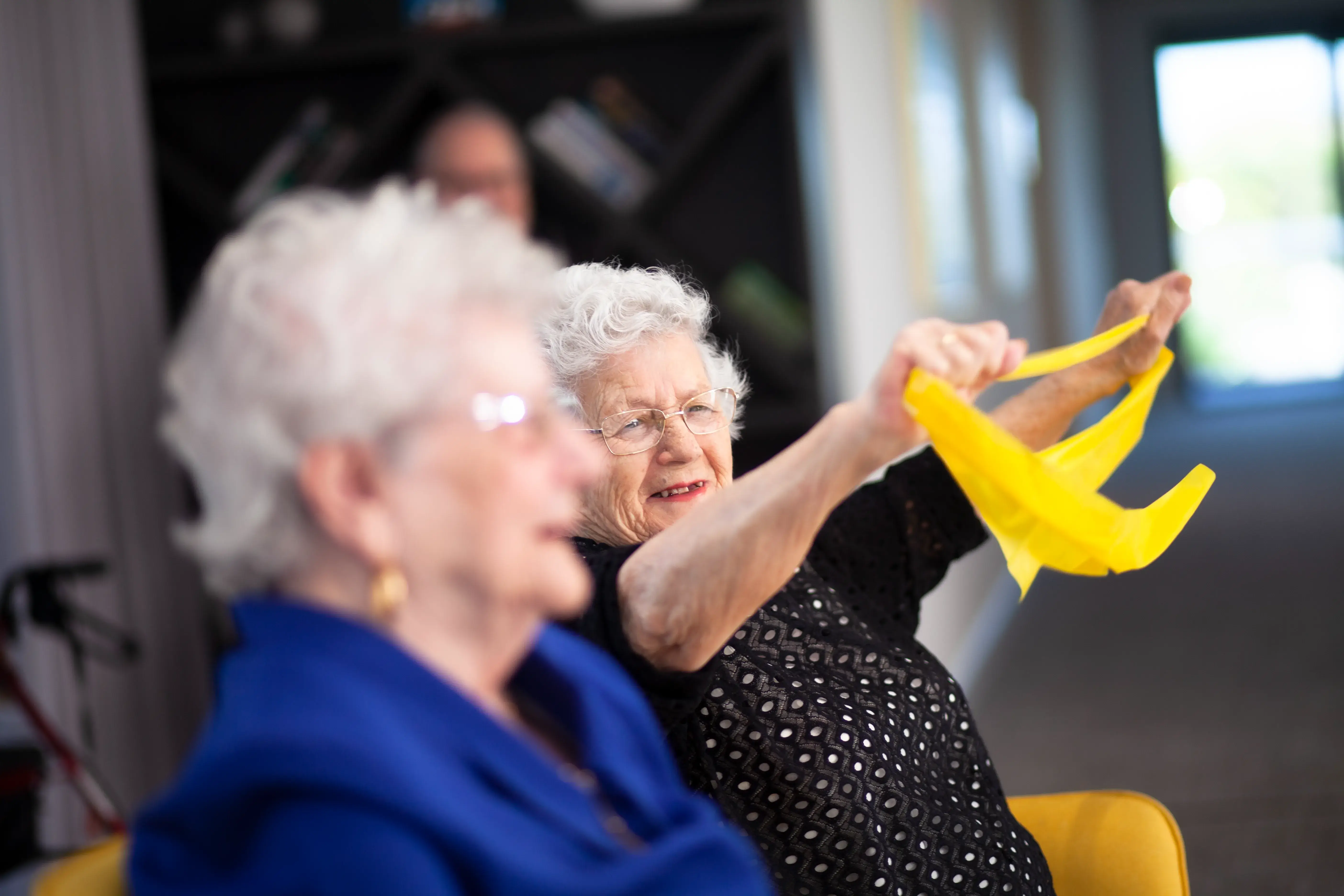 Resident participating in a gentle seated exercise session.