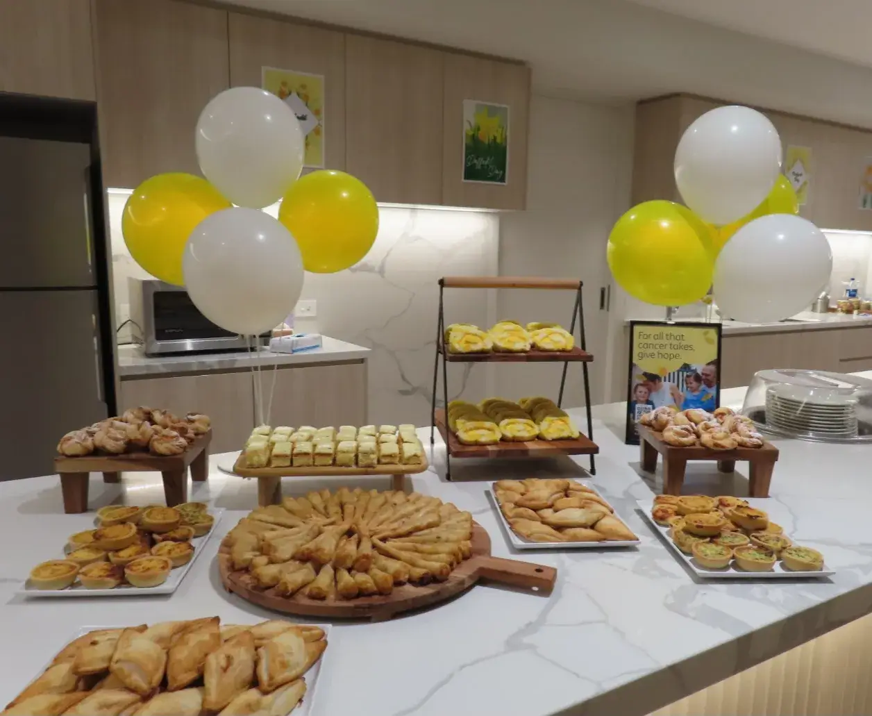A decorated kitchen bench displaying homemade baked goods prepared for a special community event.