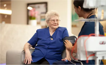 A female staff member getting the blood pressure measurements of an elderly resident during a routine checkup.