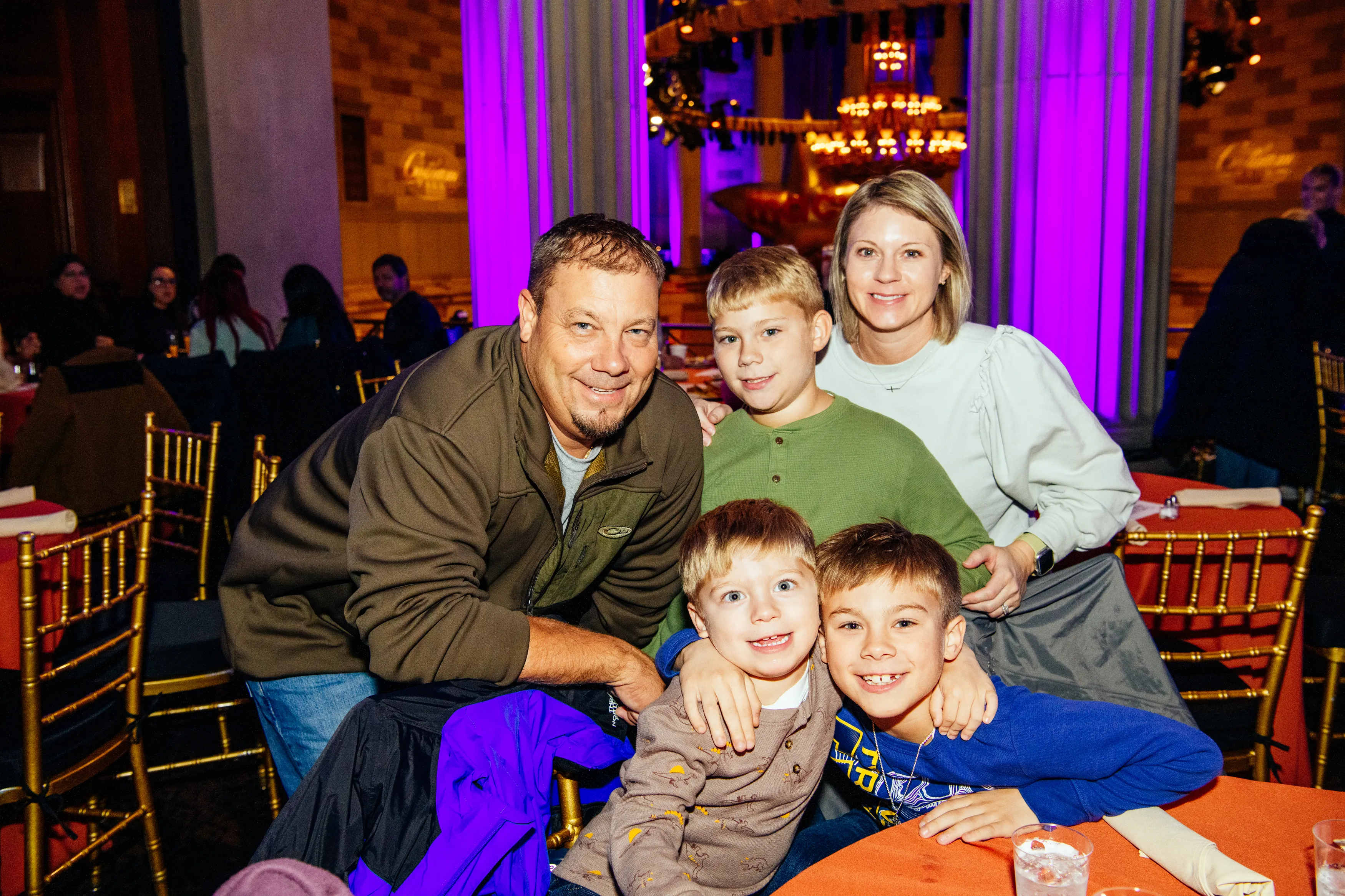 A family with two young boys smiling at their table at Gotham Hall