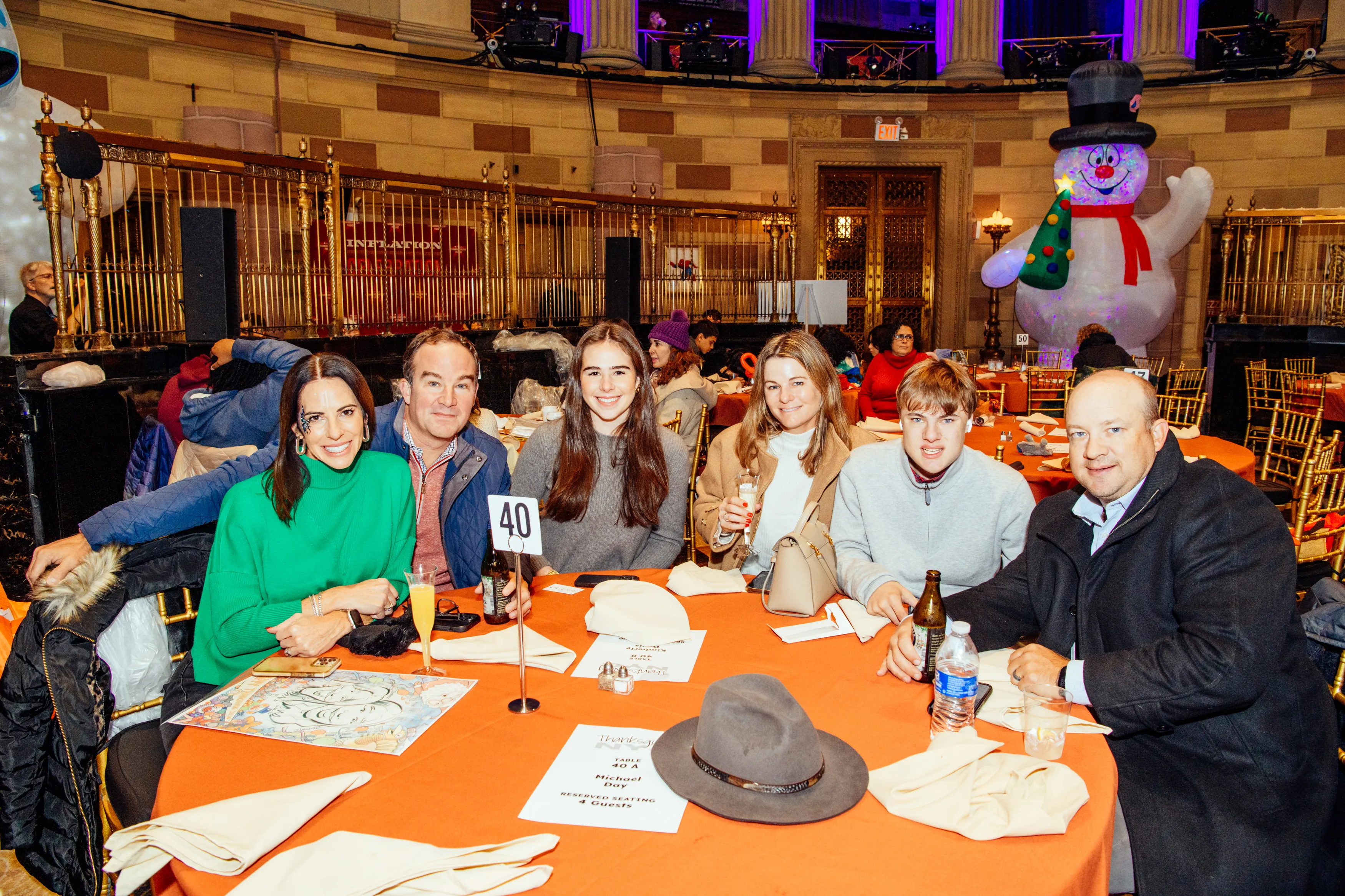 Guests at their table with an inflatable snowman behind them at Gotham Hall