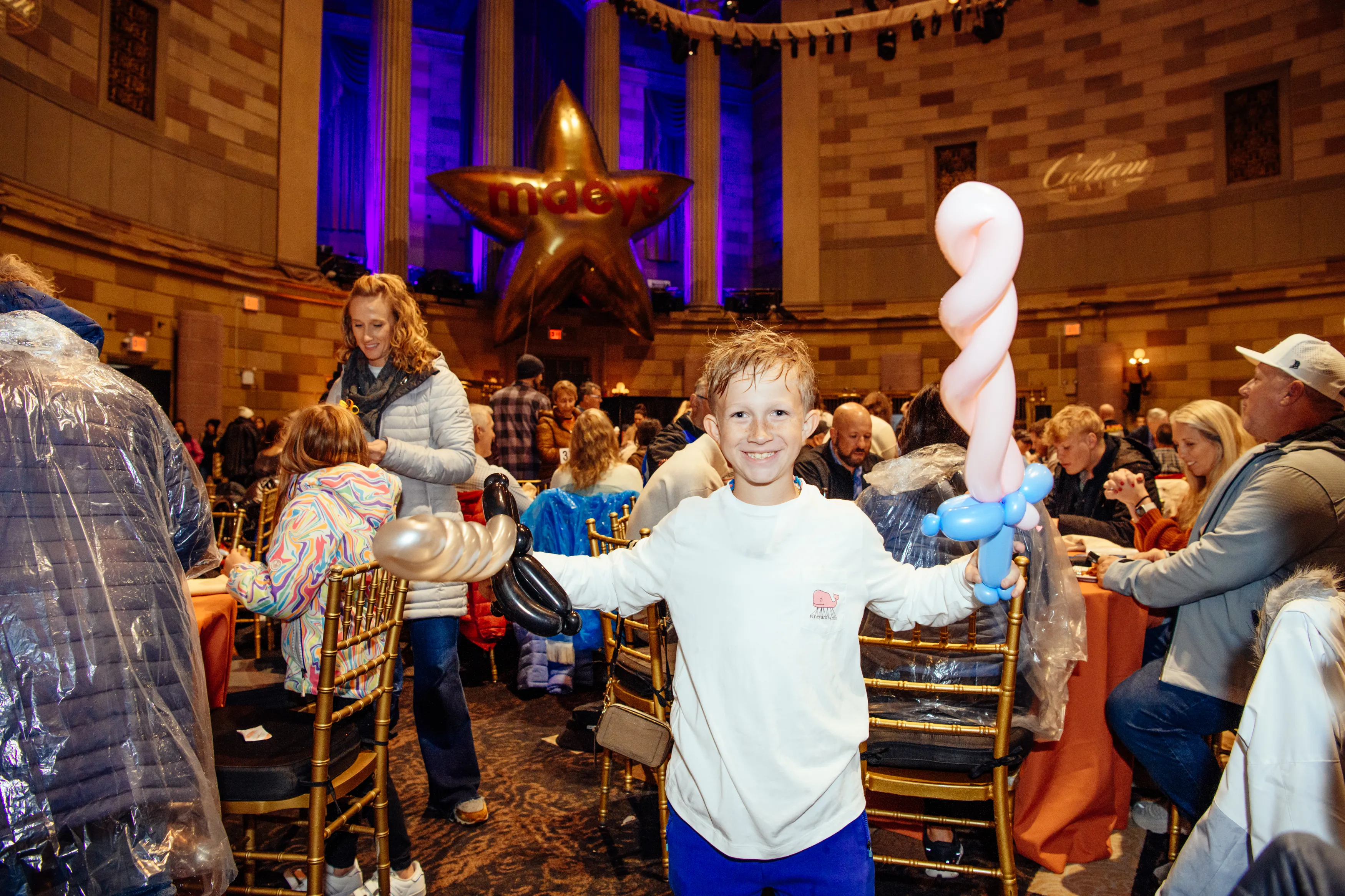 A boy holding a balloon sculpture made by the balloon artist at Gotham Hall