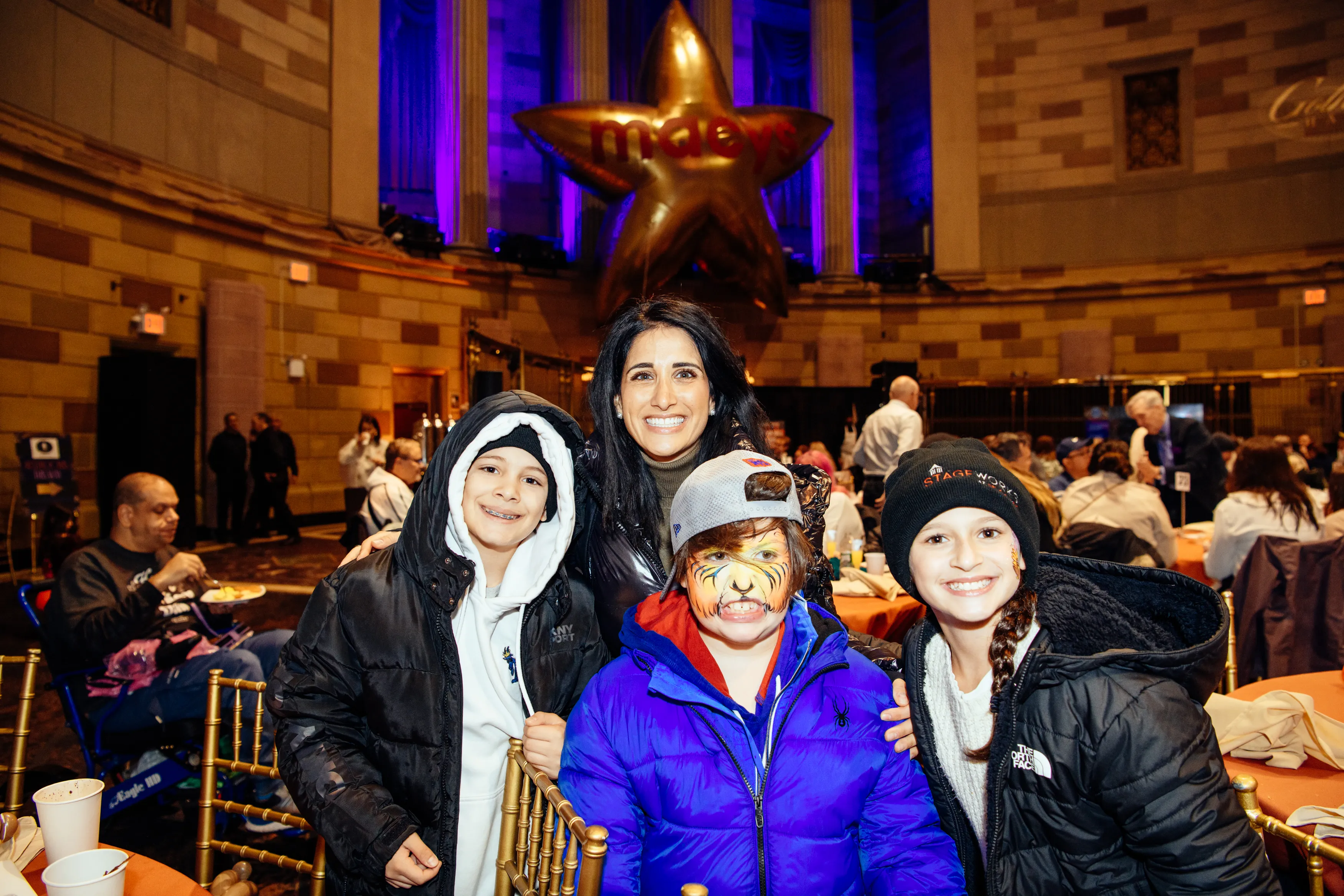 Kids with face paint posing with a parent in the Gotham Hall ballroom