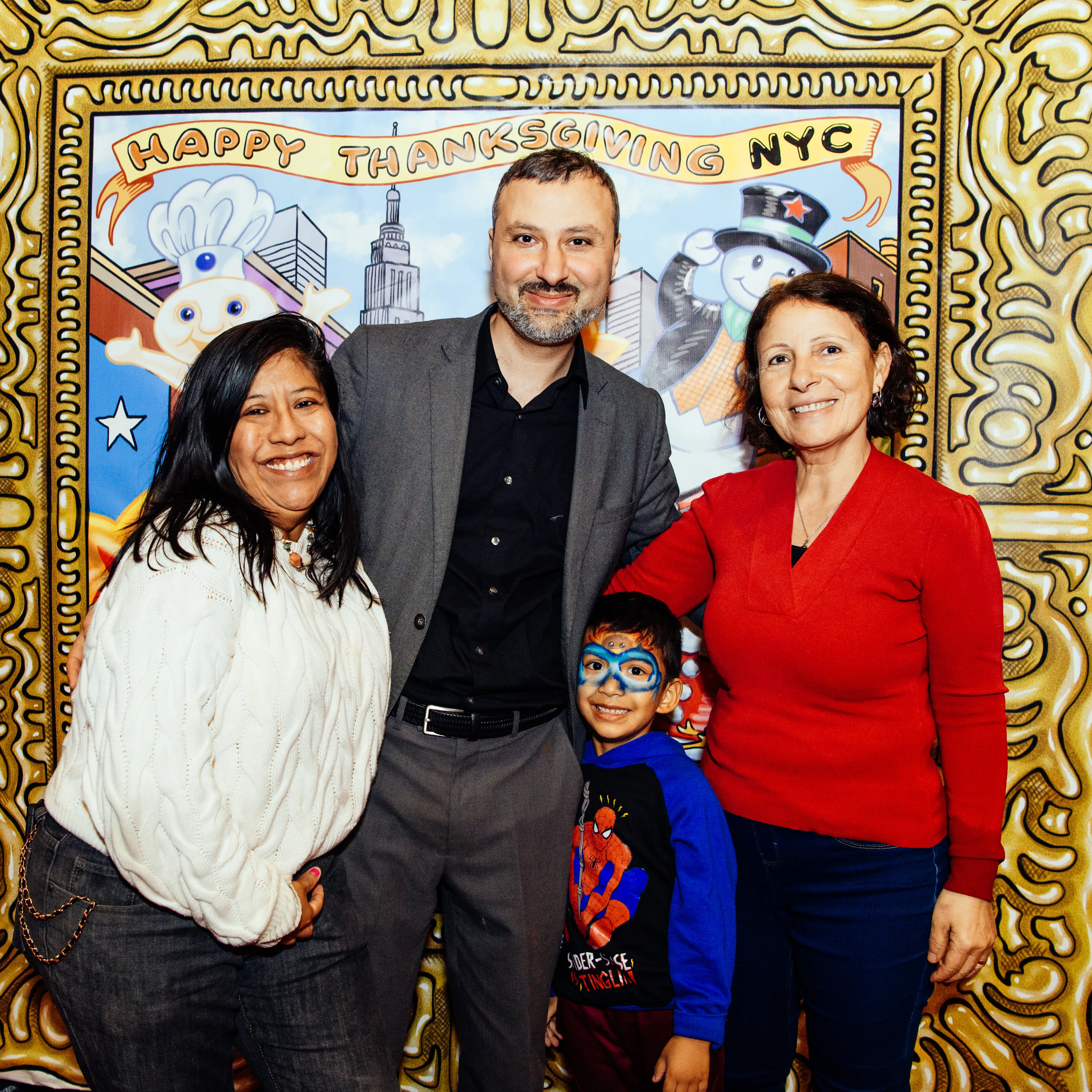 A family posing at the Happy Thanksgiving NYC photo backdrop at Gotham Hall