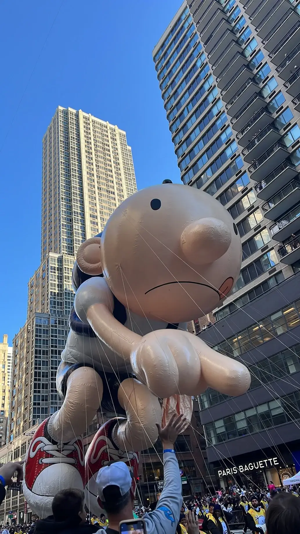 Guest photo: the Diary of a Wimpy Kid balloon floating between Midtown buildings during the Thanksgiving Day Parade