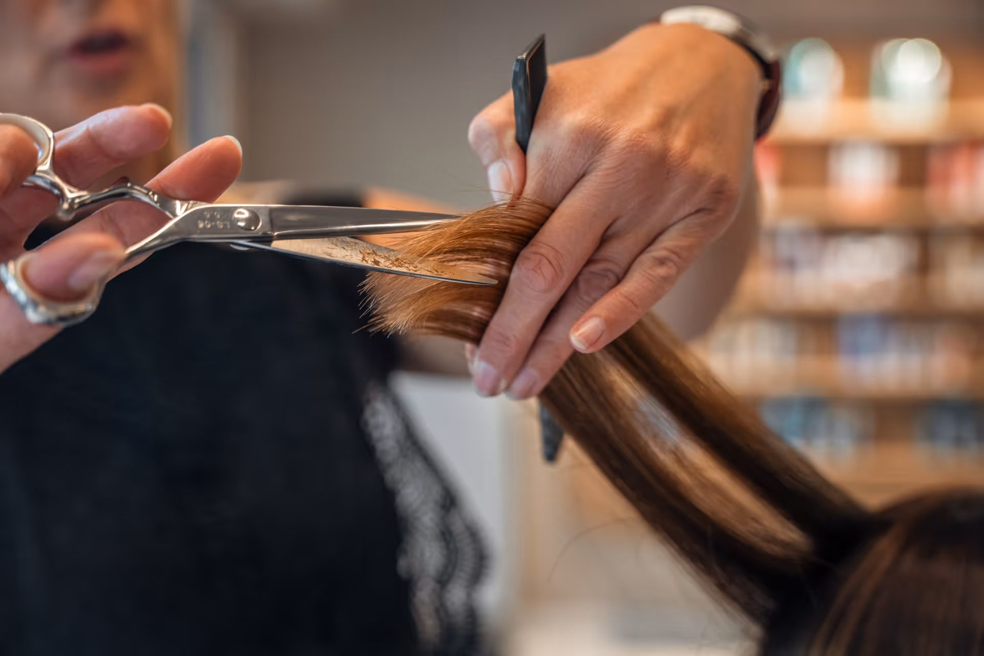 Close-up van een kapper die bruin haar aan het knippen is in kapsalon Skelte.