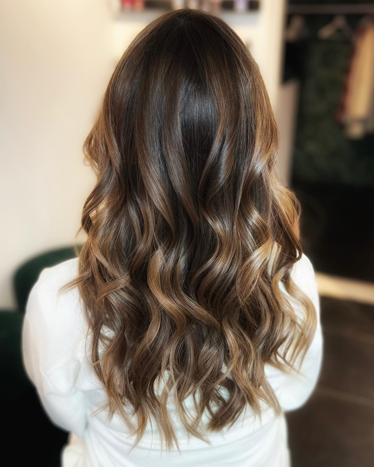 Lang donkerbruin kapsel met zachte golven.