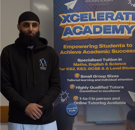 Xcelerate Academy Owner standing beside a poster