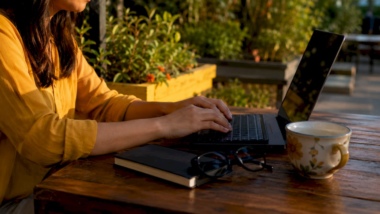 Overhead view of hands typing at home office desk