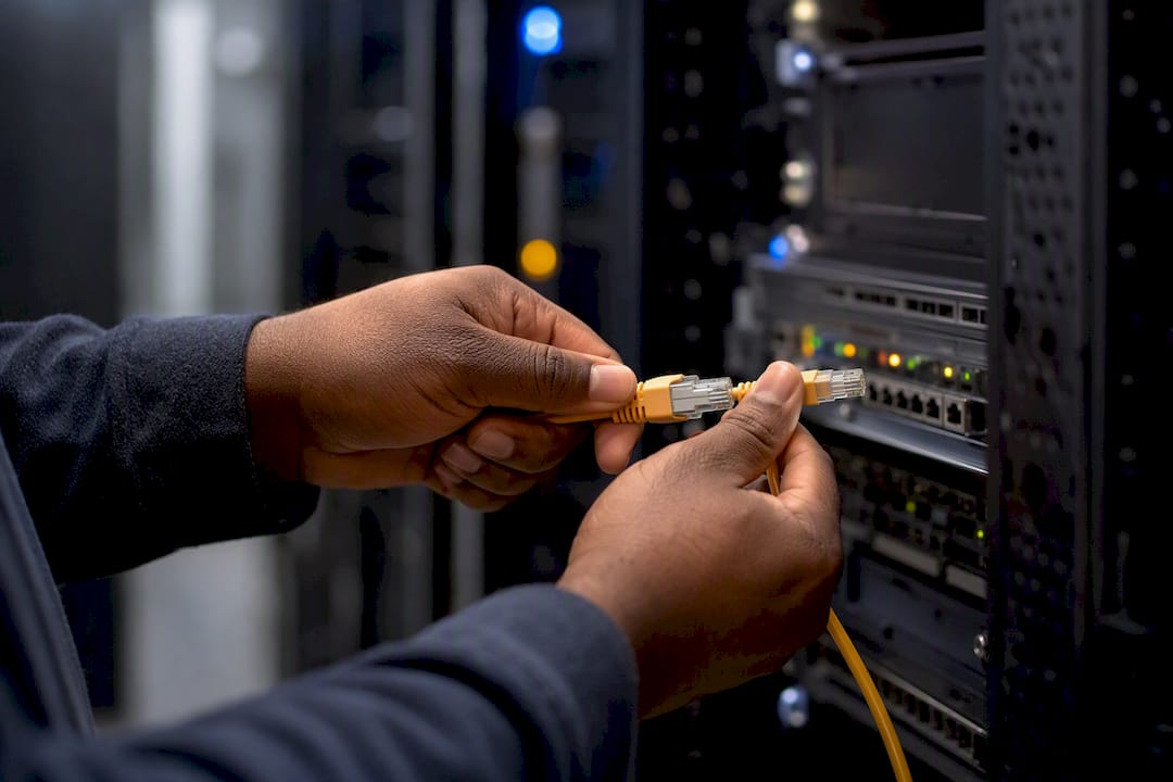 Hands connecting network cables in operations room