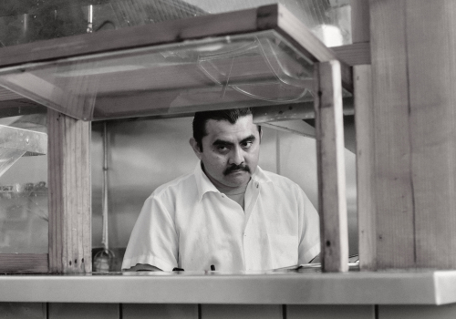 A black and white photo of Giovanni Russo in the kitchen.