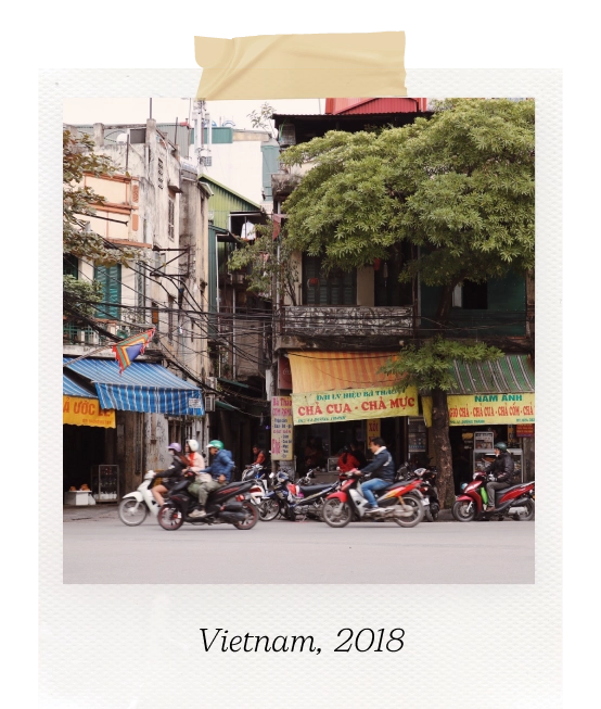Polaroid picture of a street in Vietnam with motorcyclists passing by. Caption reads "Vietnam, 2018".