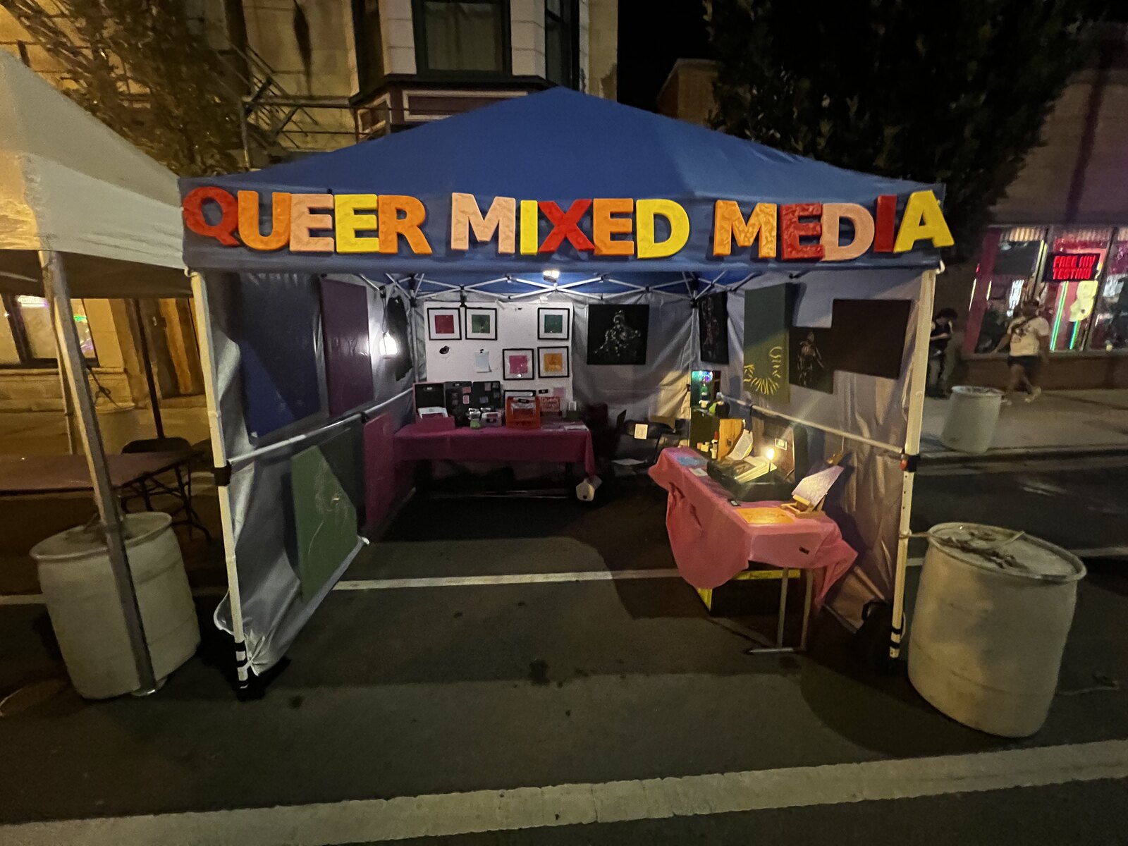 Q.M.M. booth at Northalsted Market Days at night, Chicago