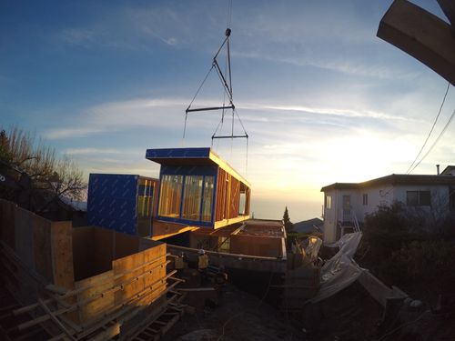 An on-site crane installing sections of a prefabricated home