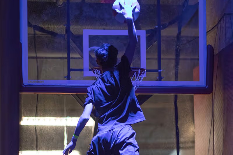 Kid dunking a basketball off a trampoline at Big Air
