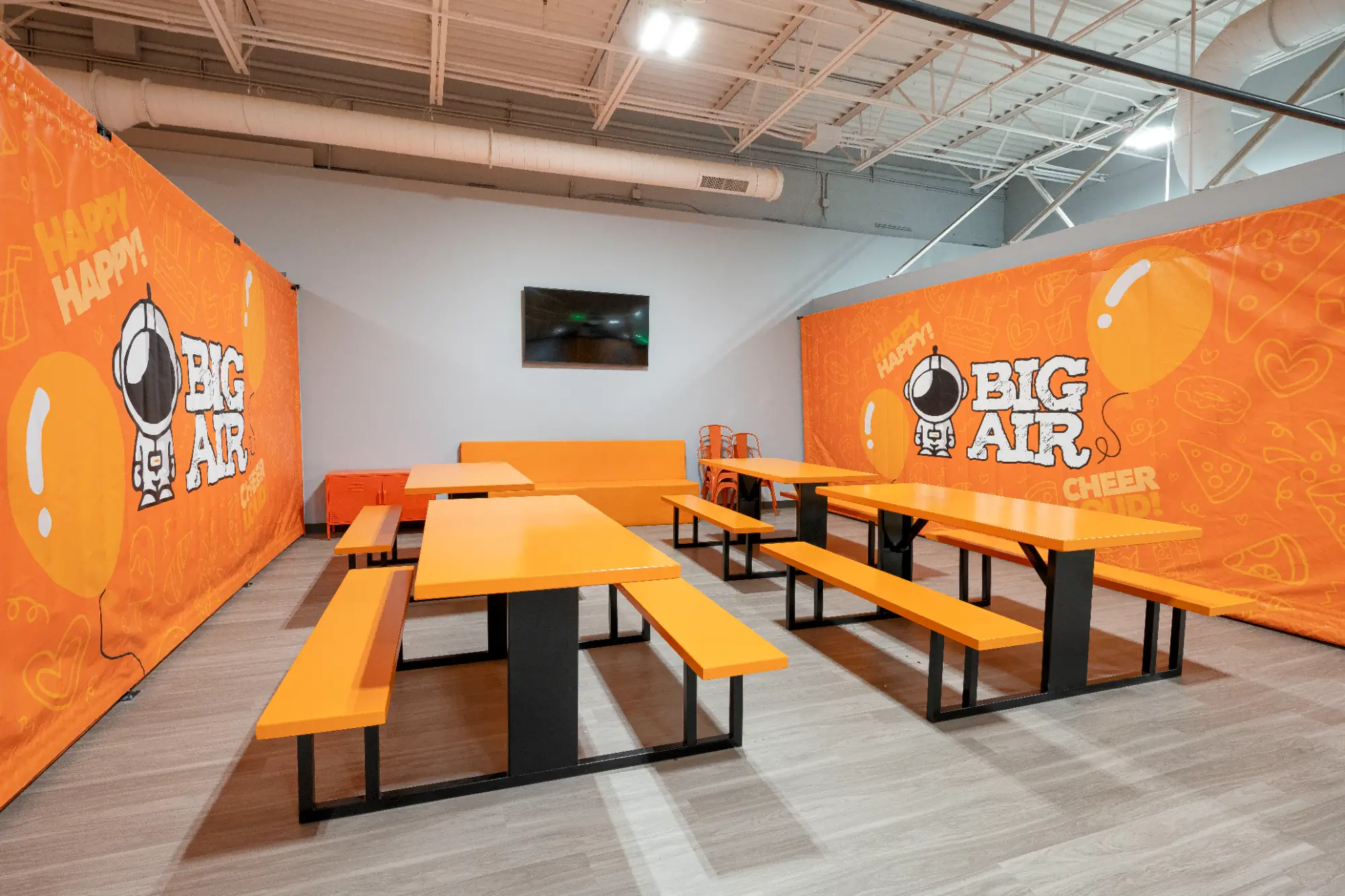 A private birthday party room with orange tables at a Big Air indoor adventure park