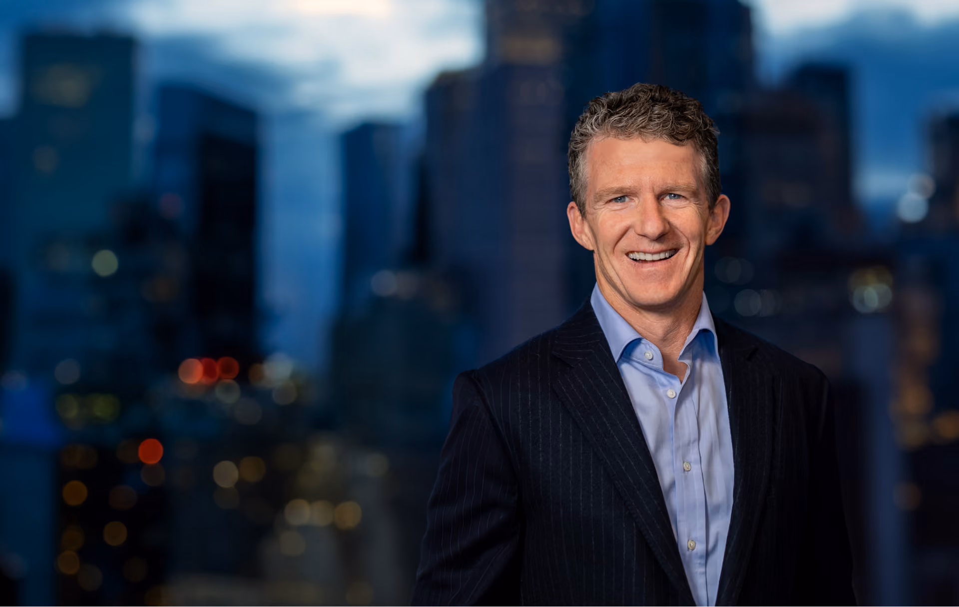 A man standing in front of a city skyline.
