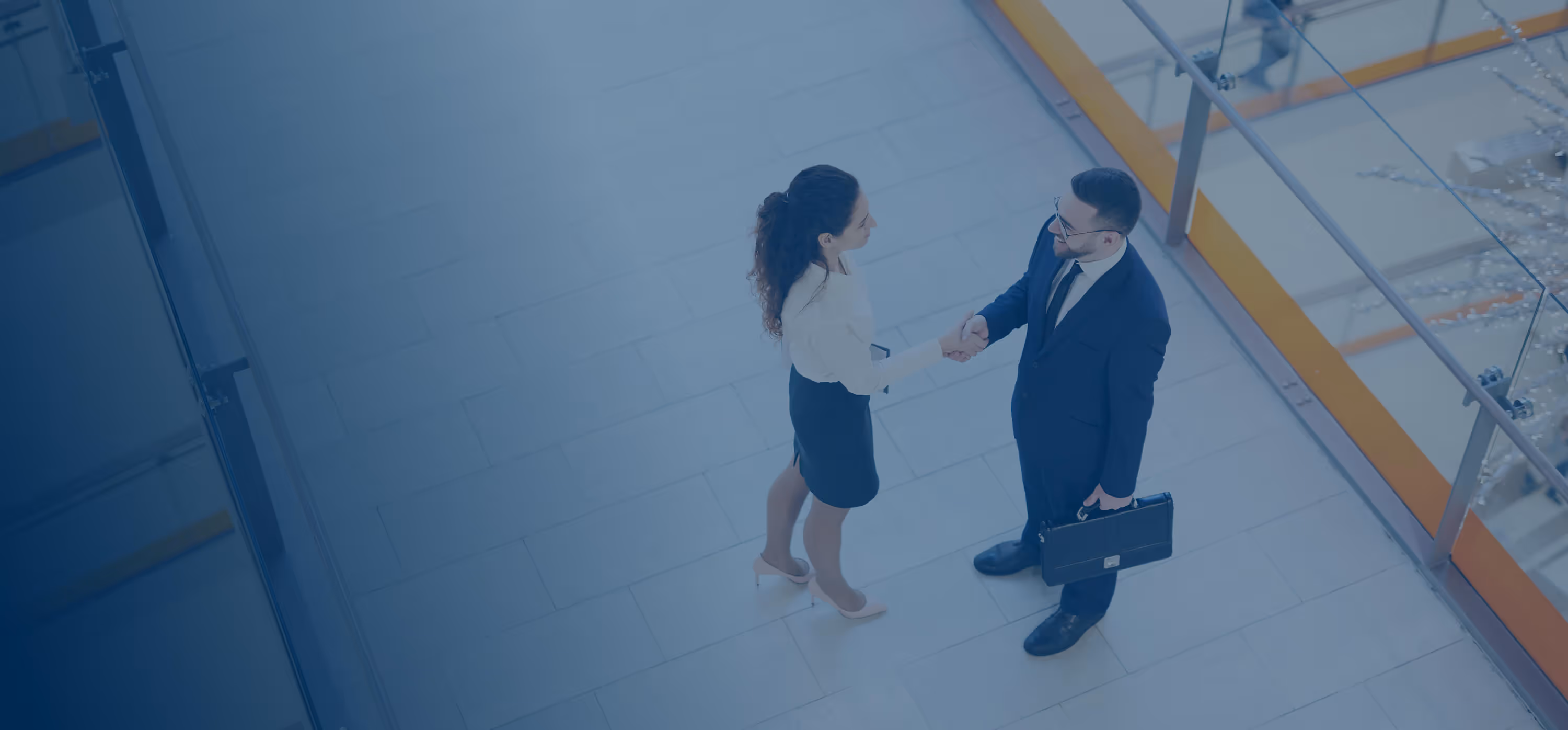 A man and a woman shaking hands in a building.