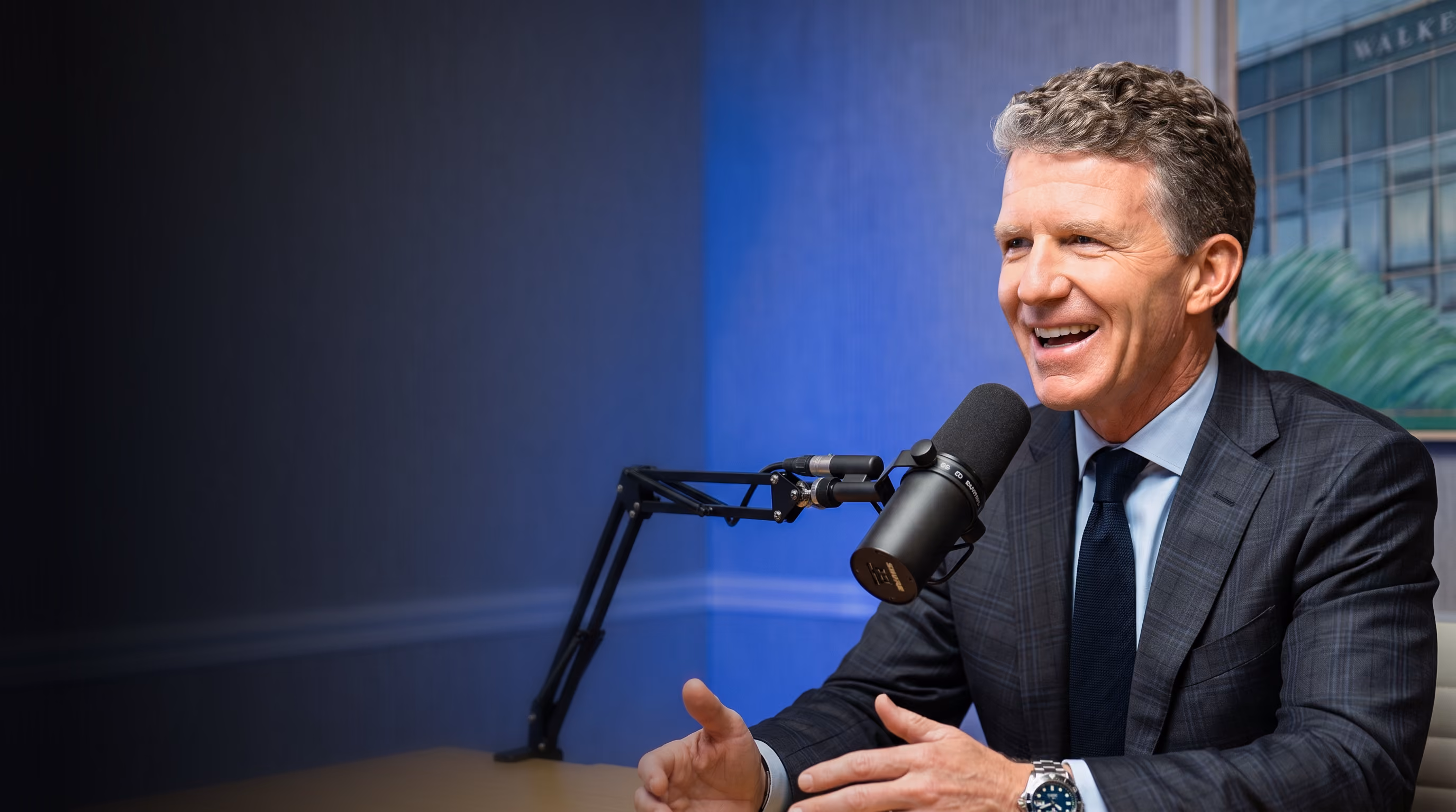 Willy Walker, CEO of Walker & Dunlop, speaking into a studio microphone while hosting the Walker Webcast