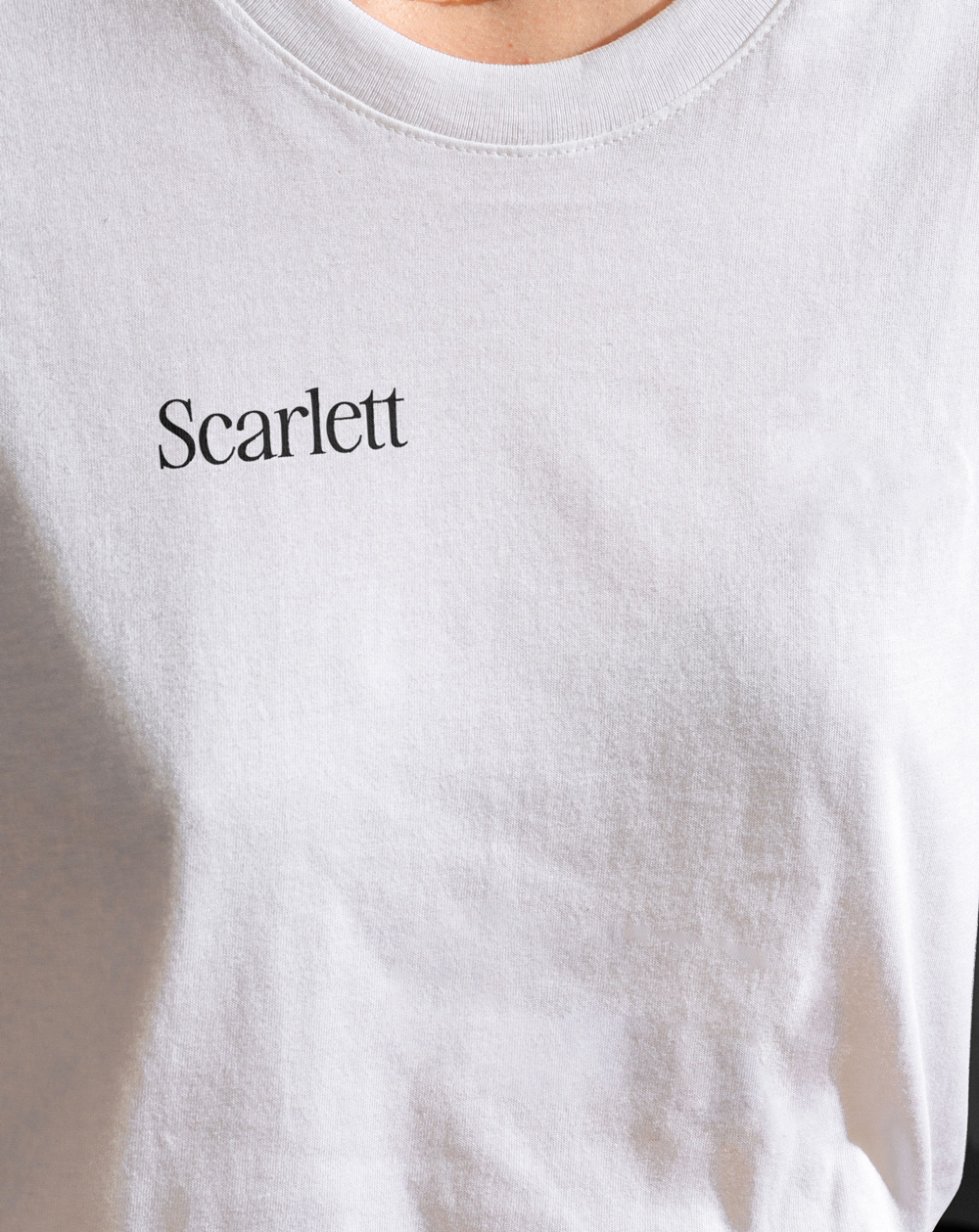 Close up of a womans t-shirt that has DTF printing on it that says Scarlett