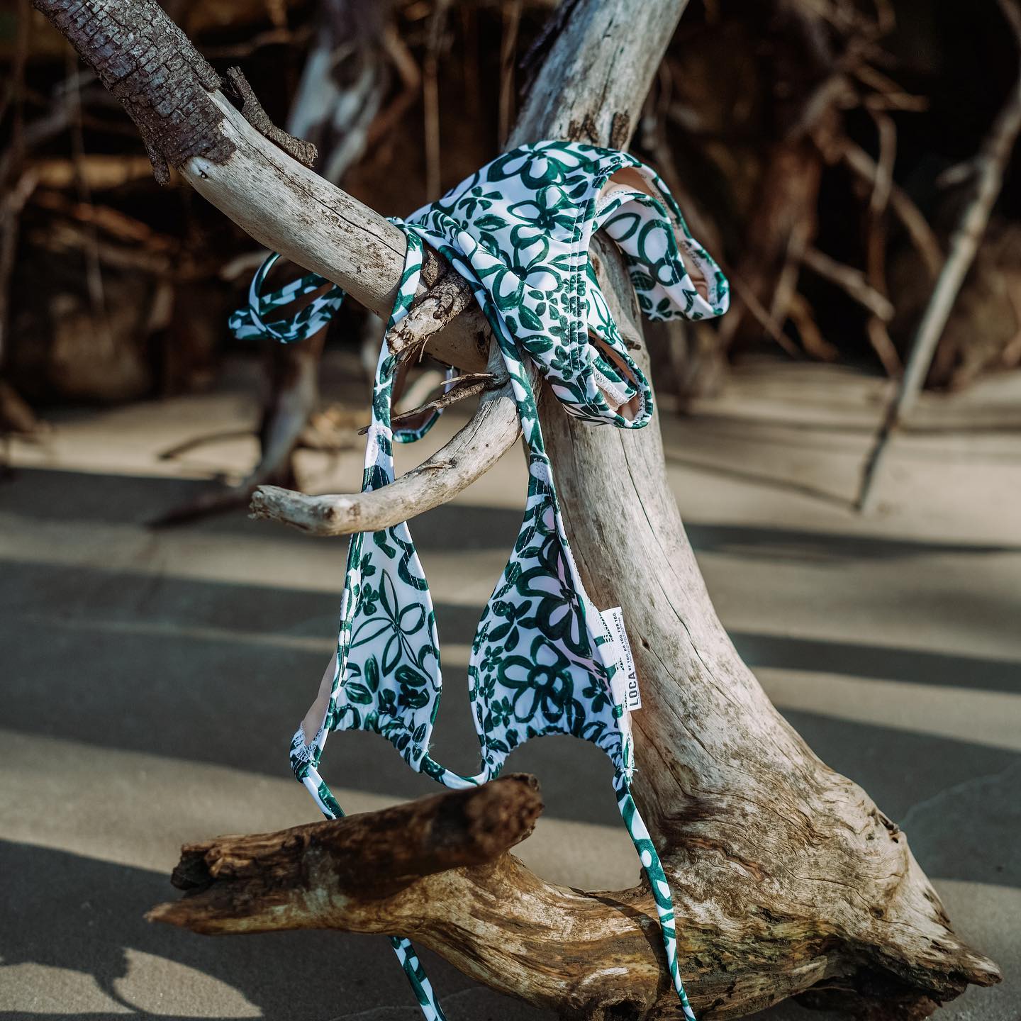 Custom printed swimsuit hanging from a tree branch