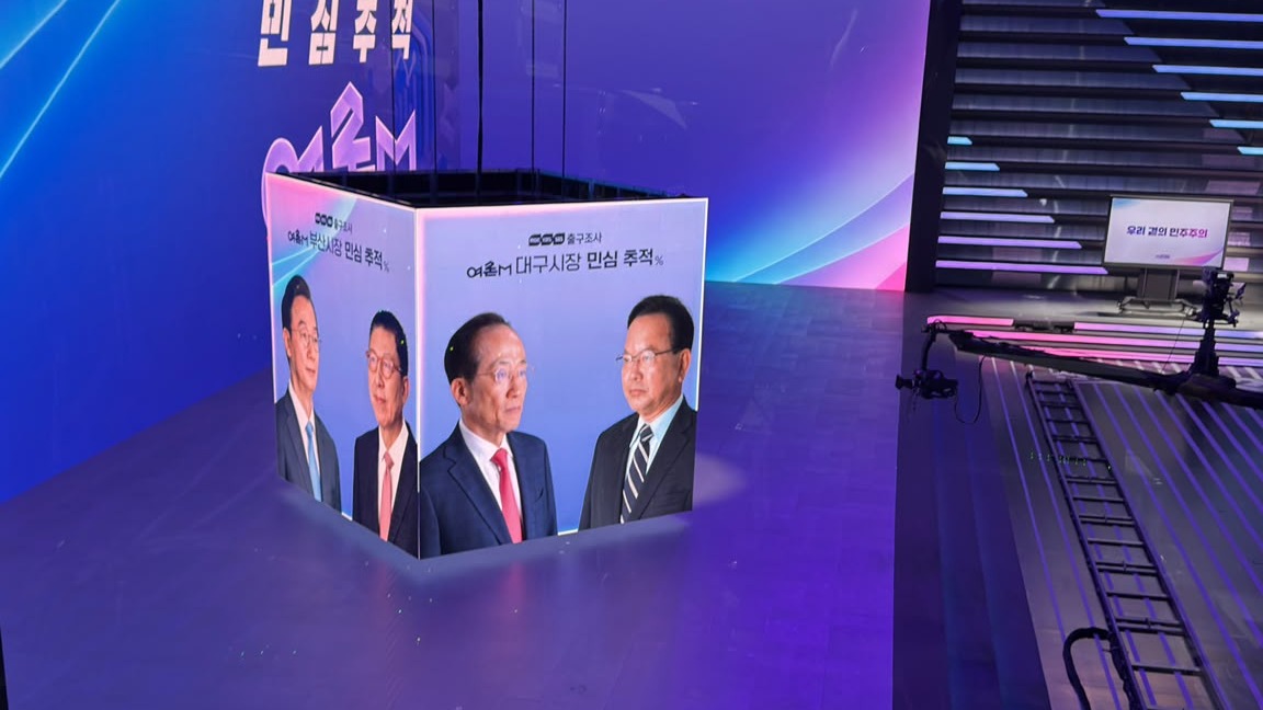 Exit poll candidate graphics rendered as a 3D cube on the MBC studio LED floor during the Korean local elections telecast