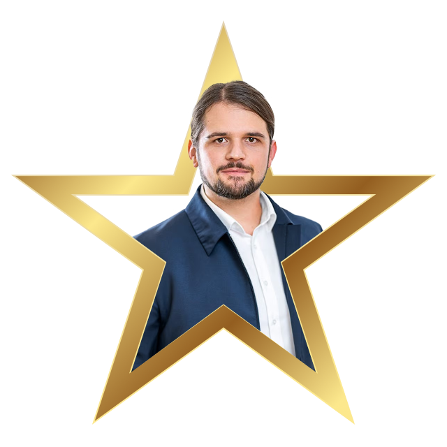 Man with dark hair and beard wearing a white shirt and blue jacket inside a gold star frame.