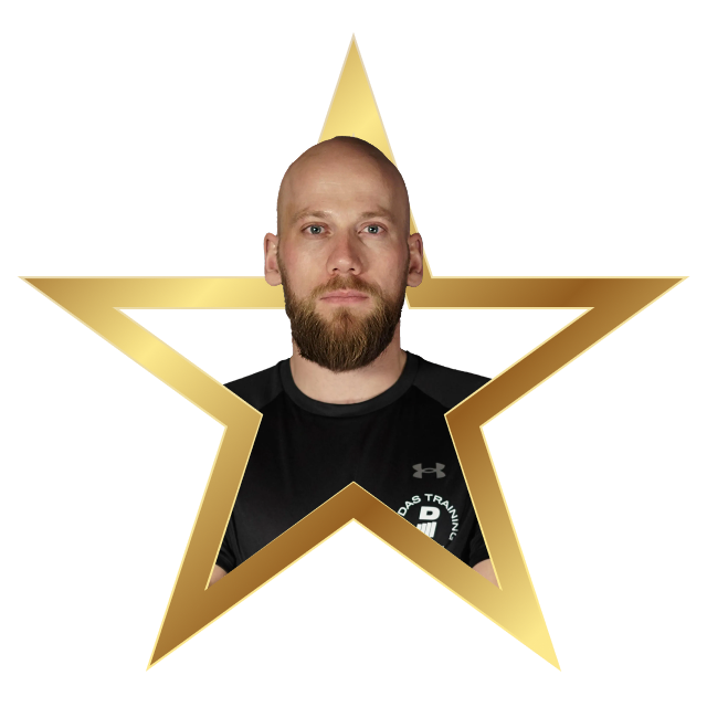 Portrait of a bald man with a beard wearing a black Under Armour shirt framed inside a gold star outline.