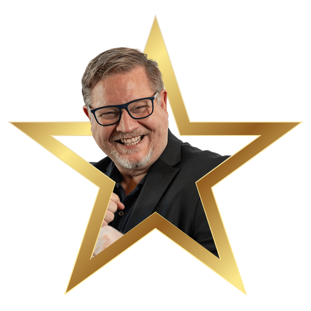 Smiling middle-aged man with glasses wearing a dark blazer inside a gold star frame.