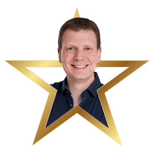 Smiling man with short brown hair wearing a dark blue shirt, framed inside a gold star outline.