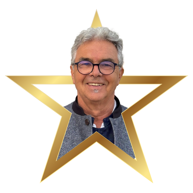 Smiling middle-aged man with gray hair and glasses inside a gold star frame.