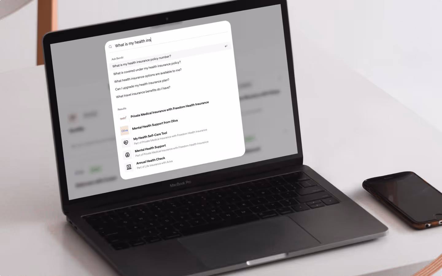 A photo of a laptop that shows Ben's AI search functionality answering a health insurance question