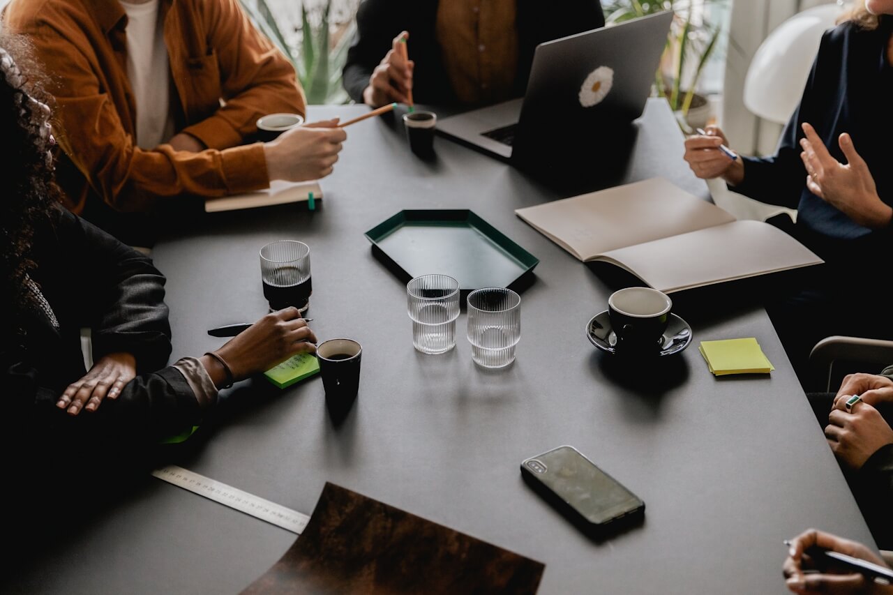 A team in discussion around a meeting table — representing the cross-functional clarity that becomes possible when benefits d