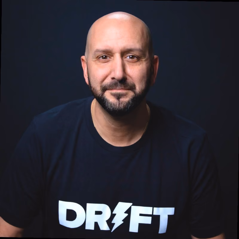 Smiling bald man with a beard wearing a black shirt with the word DRIFT in white letters.