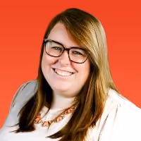 Smiling woman with glasses and long brown hair wearing a white top and necklace against a red background.