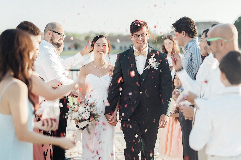 Man and woman walk down aisle after their small wedding ceremony.