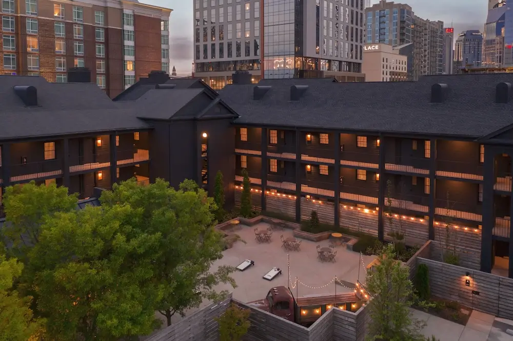 Courtyard view of BODE Nashville boutique hotel wedding venue with string lights and modern downtown skyline backdrop.
