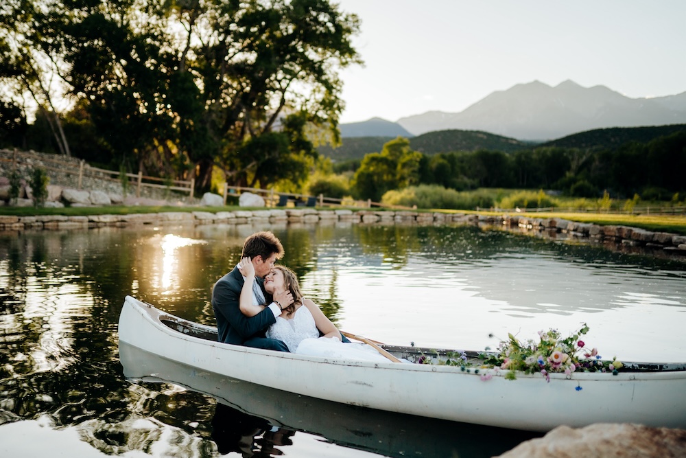 Couple embraces in a canoe at their Colorado micro wedding venue, Shaw’s River Ranch.