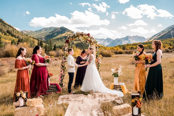 A couple at their wedding ceremony overlooking mountains on public land in the fall.