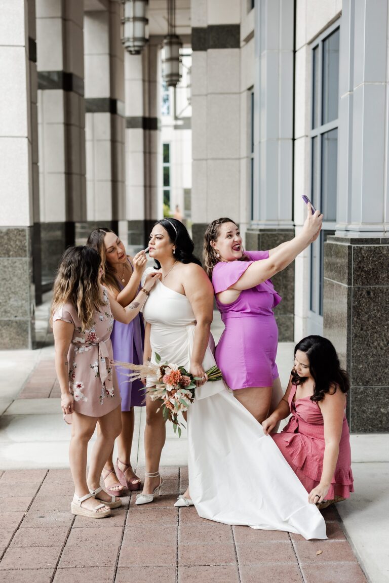 A wedding party poses for portraits before a courthouse ceremony.