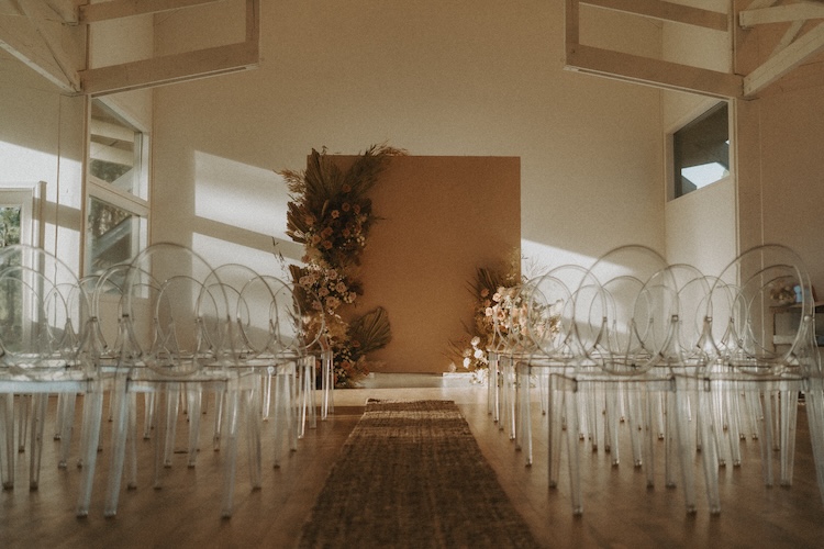 Couple shares an embrace at sunset on a private-home micro wedding venue with golden grass and warm light
