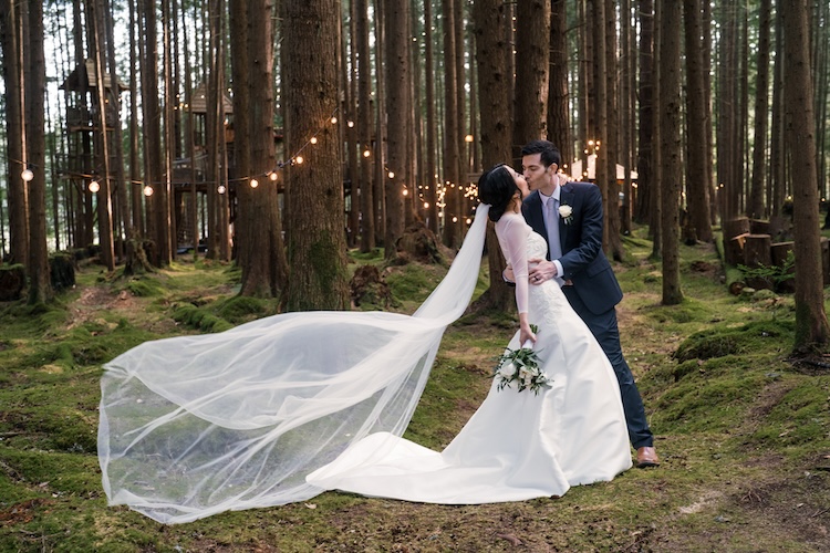 Couple at a small wedding ceremony with a lush Pacific Northwest forest backdrop and soft natural light