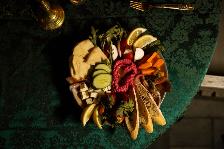 Individual charcuterie plate with cheese, meats, and fruit, plated for an intimate wedding dinner