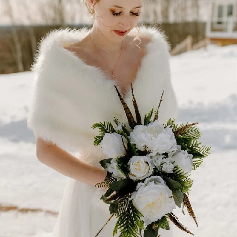 Cream-colored faux-fur bridal shrug from Etsy, styled over a wedding gown for a winter wedding party look